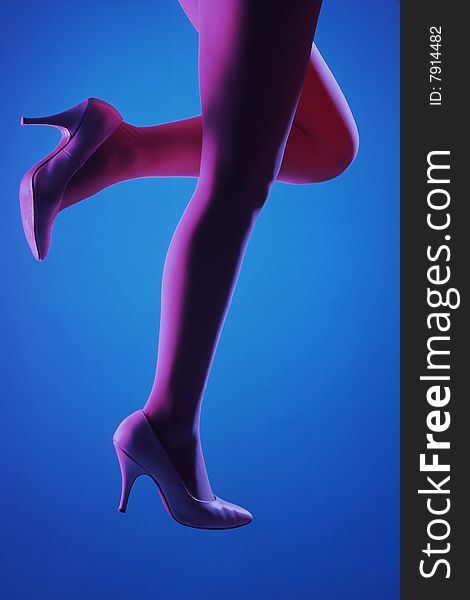 Model's legs in pink tights and white heels on blue background, levitated. Model's legs in pink tights and white heels on blue background, levitated.