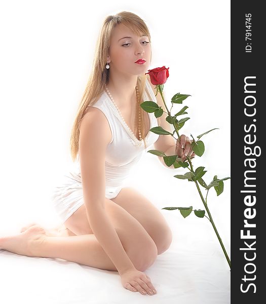 Beautiful young woman with rose on white background