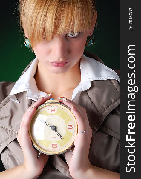 Beautiful woman with alarm clock on a black background