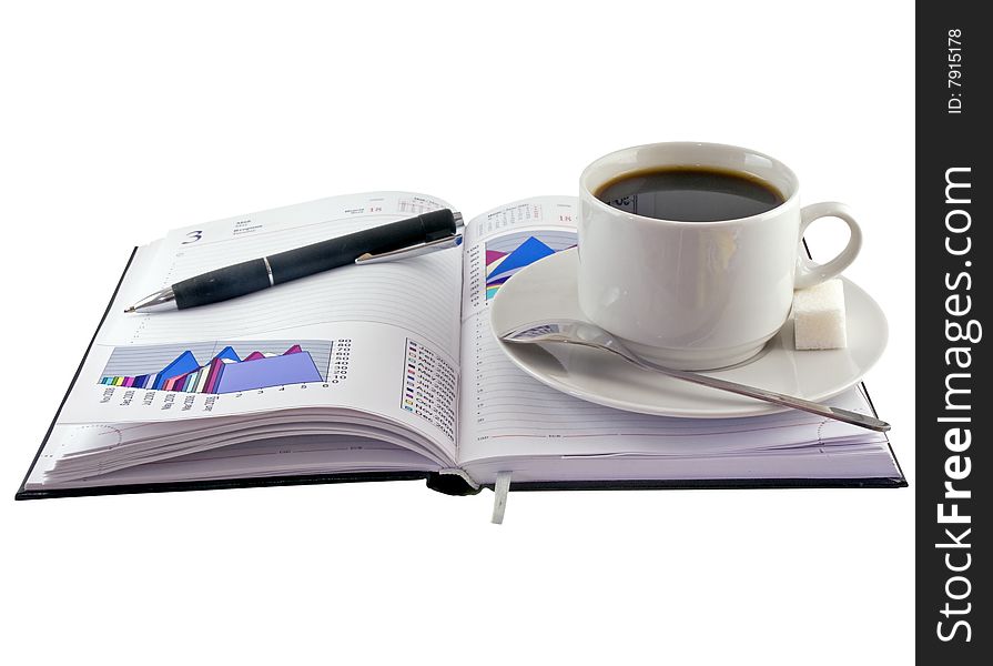 Coffee cup, pen, standing on  personal organizer.