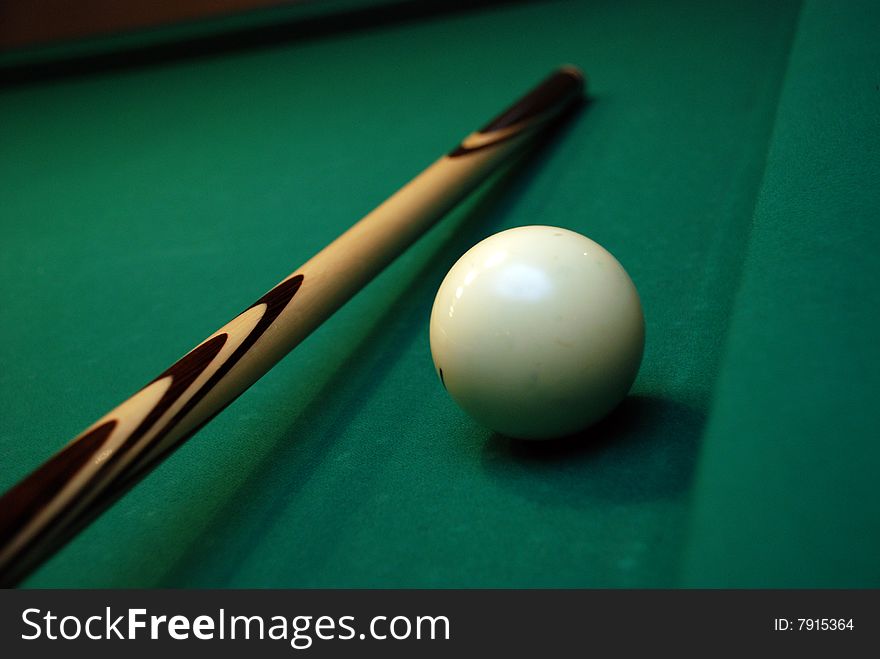 Picture of green billiard table with white ball and cue