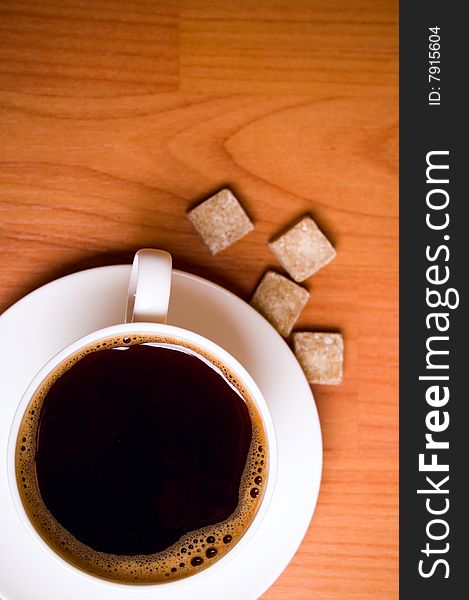 Cup of coffee and sugar on wooden table