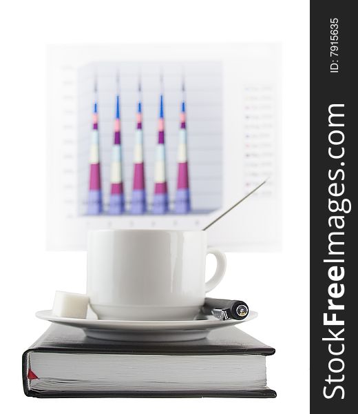 Coffee cup, standing on the black personal organizer, on a back background - financial  diagram . Focus at the pen and cup.Isolated on white. Coffee cup, standing on the black personal organizer, on a back background - financial  diagram . Focus at the pen and cup.Isolated on white.