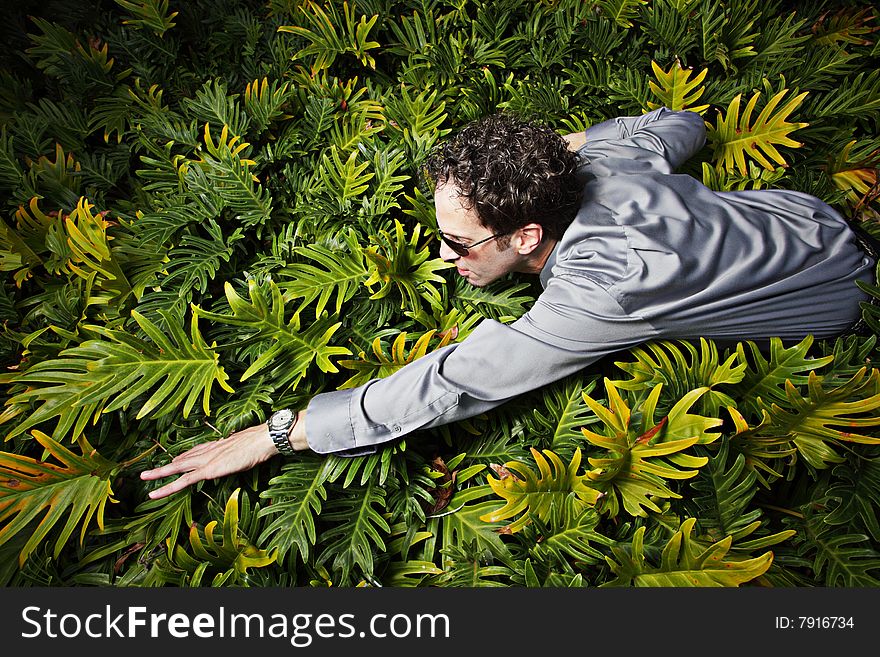Businessman swimming through a field of green plants. Businessman swimming through a field of green plants