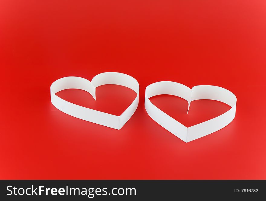 Two white hearts,on red background.