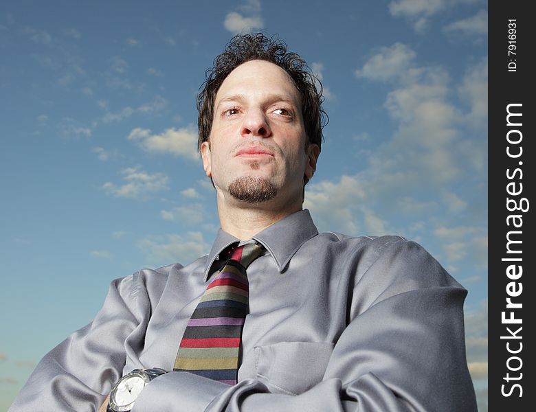 Young businessman on a cloudy blue sky. Young businessman on a cloudy blue sky