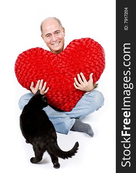 A handsome Latin man sitting holding a big red heart. A handsome Latin man sitting holding a big red heart.