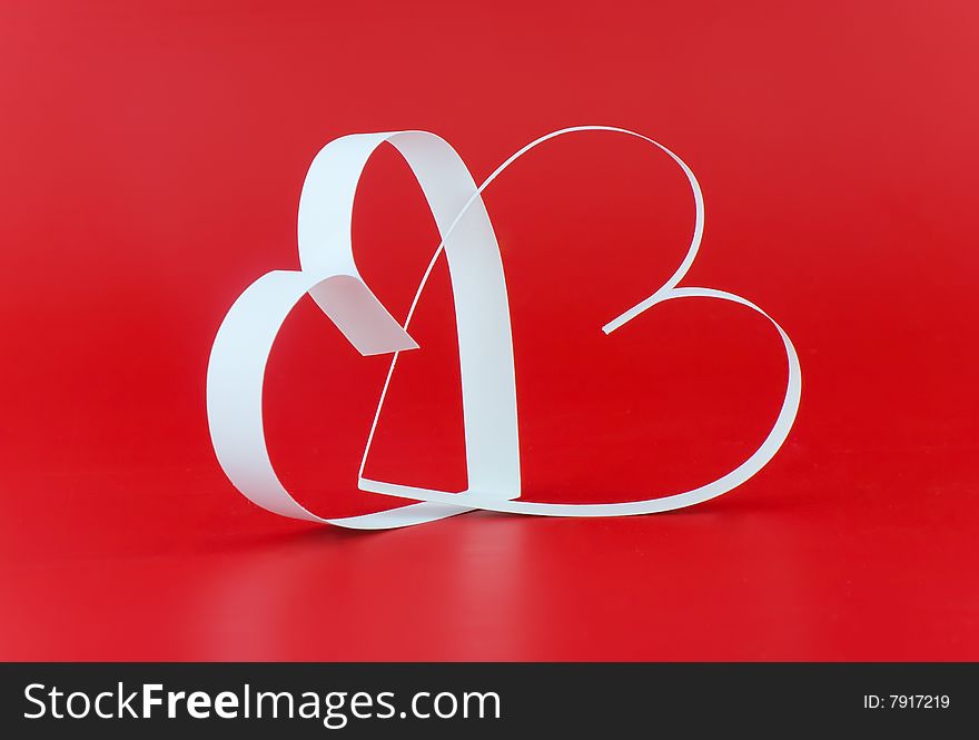 Two white hearts,on red background.