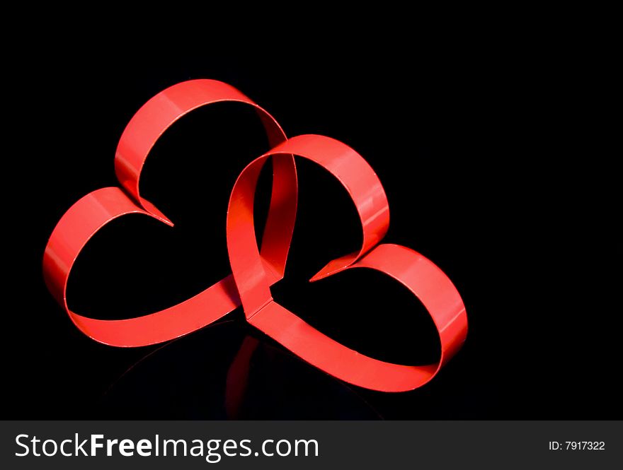 Two hearts with center spot light, on black  background. Two hearts with center spot light, on black  background.