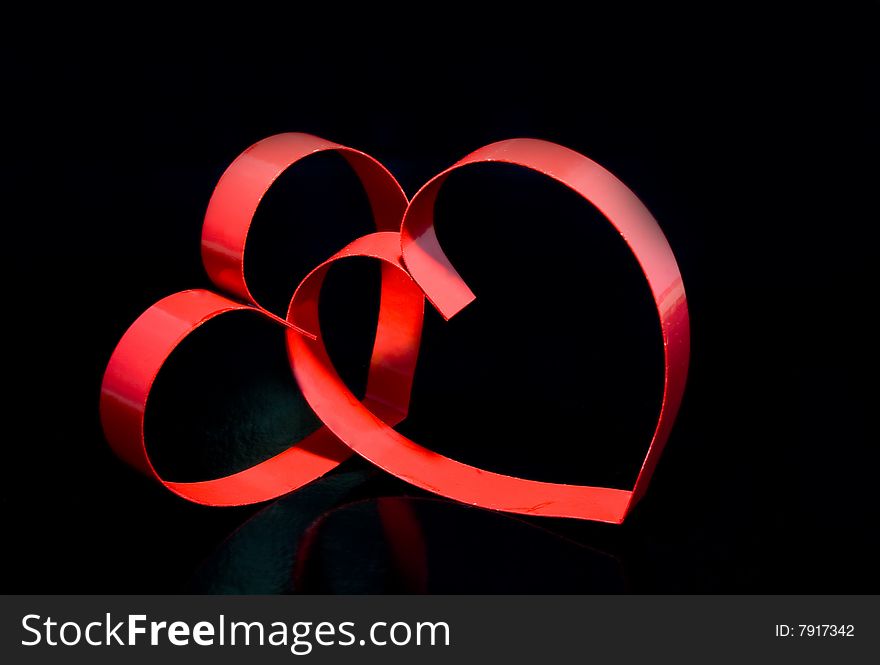 Two hearts with center spot light, on black  background. Two hearts with center spot light, on black  background.