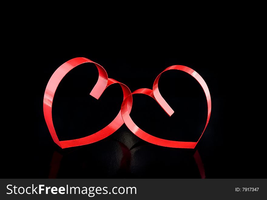 Two hearts with center spot light, on black  background. Two hearts with center spot light, on black  background.