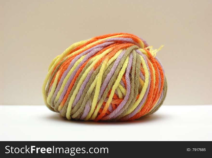 Bale of colorful yarn on a beige background