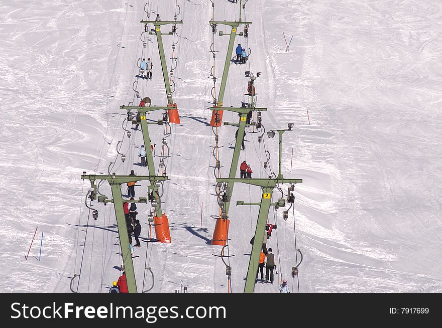 Skiers using a ski lift at a winter resort. Skiers using a ski lift at a winter resort