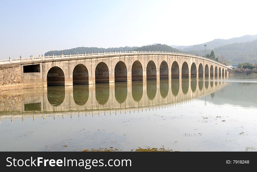 The Chinese traditional styled stone arch bridge in the lake. The Chinese traditional styled stone arch bridge in the lake.