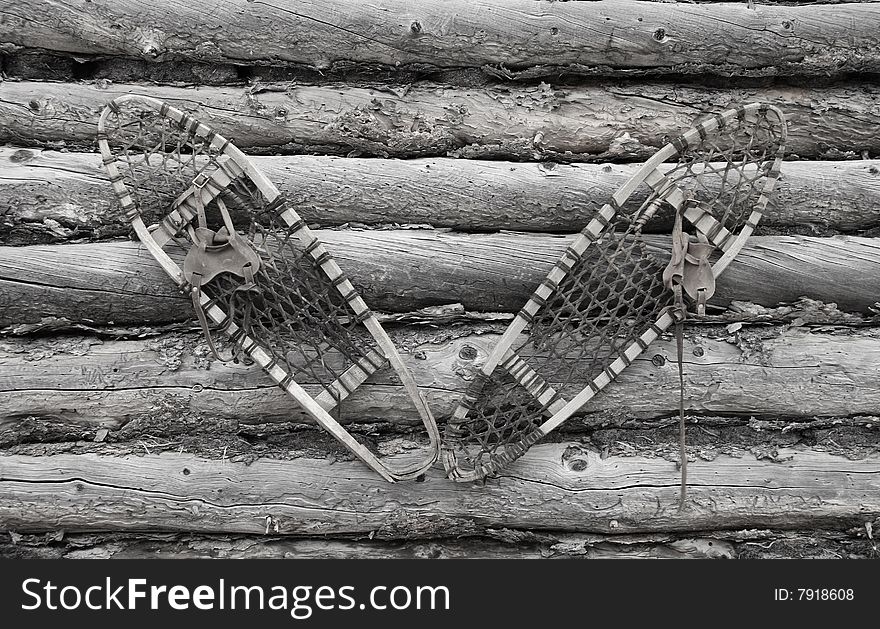 An old pair of wooden Snow Shoes hanging on a cabin wall