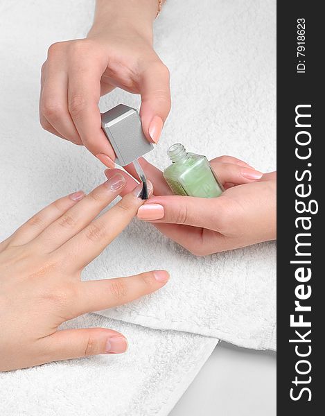 Applying manicure: moisturizing the nails and skin around nails. Applying manicure: moisturizing the nails and skin around nails