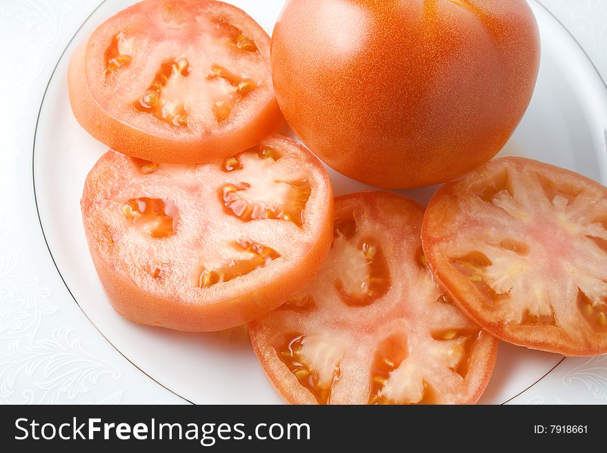 Tomato slices in dish with whole tomato