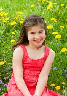Girl Smiling In Front Of Flowers Stock Photo
