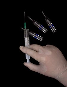 Syringe In A Hand And Ampoules Stock Images