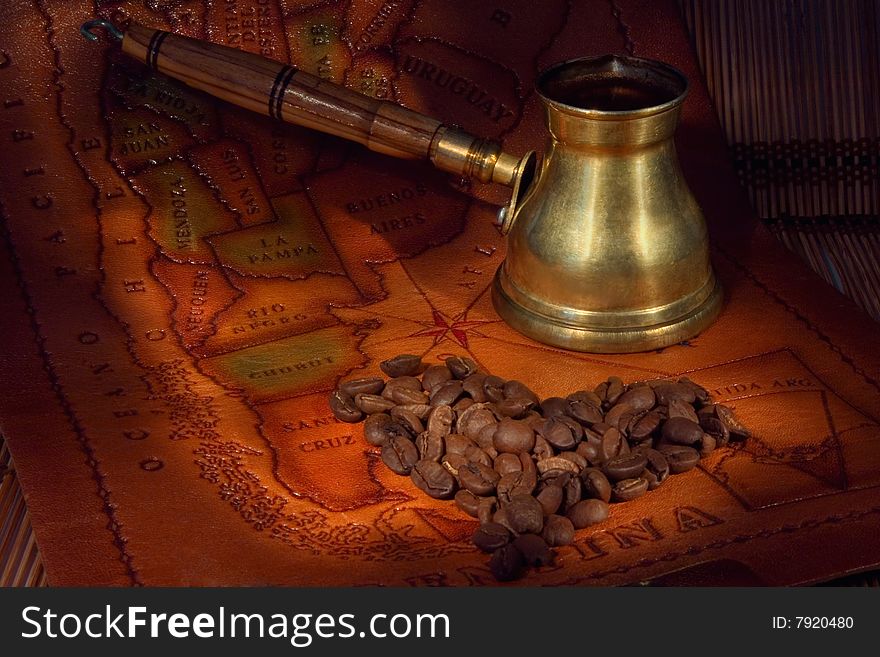 Coffee in a turk and grains on map of the South America. Coffee in a turk and grains on map of the South America