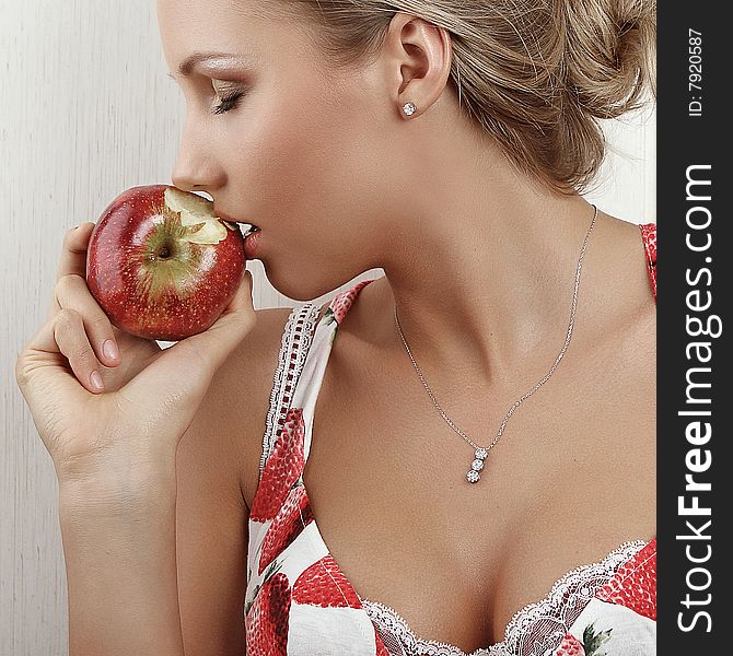 Young attractive female holding and kissing an red apple. Young attractive female holding and kissing an red apple