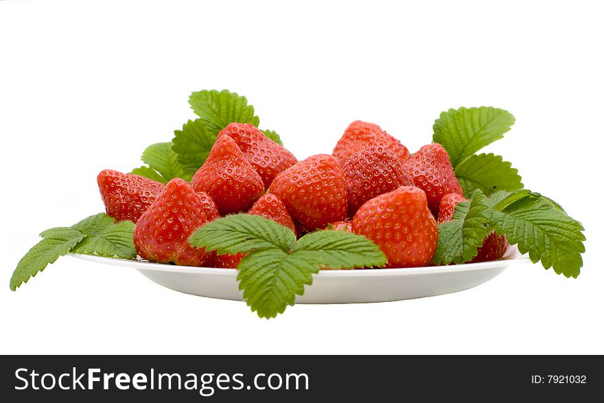 Berry and strawberry leaves on a white plate the isolated