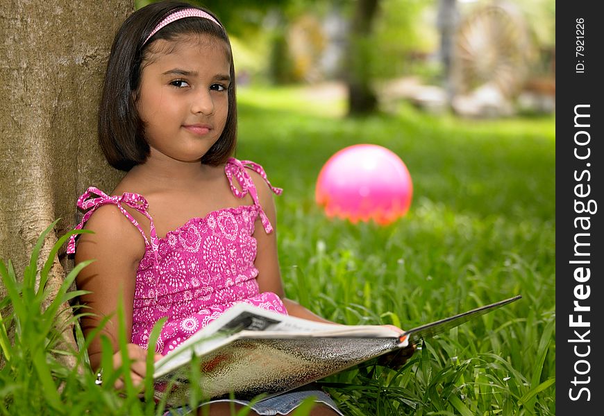 Girl Reading A Book In The Park