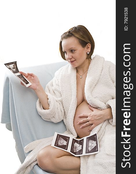 Young Pregnant woman looking on the ultrasonic sonogram in her hands. Young Pregnant woman looking on the ultrasonic sonogram in her hands