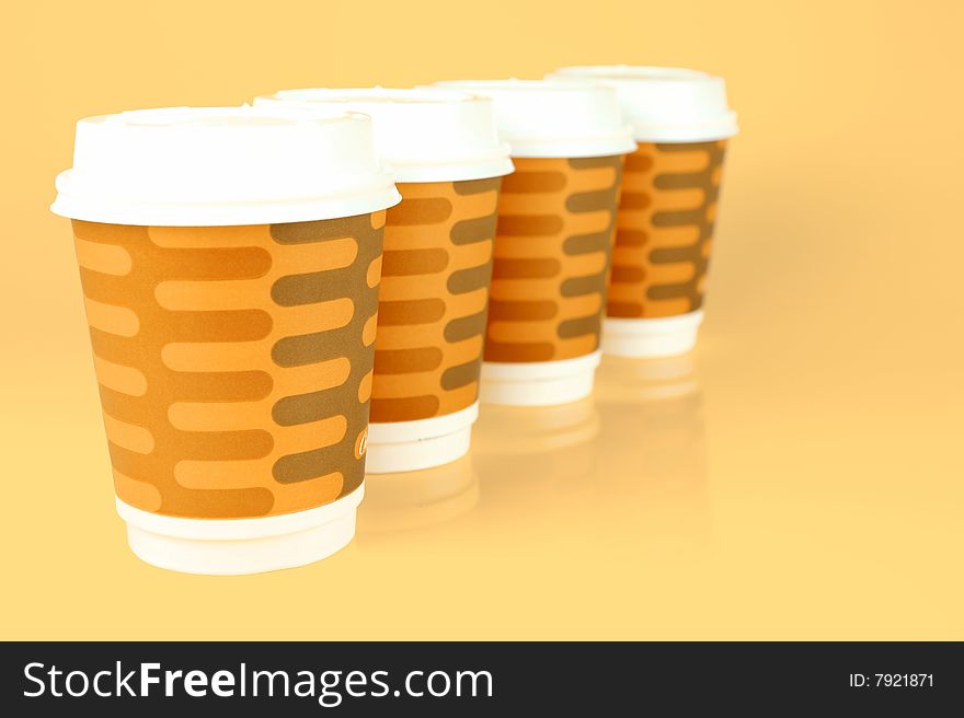 Takeaway coffee cups isolated against an orange background