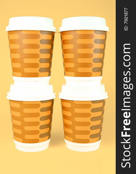 Takeaway coffee cups isolated against an orange background