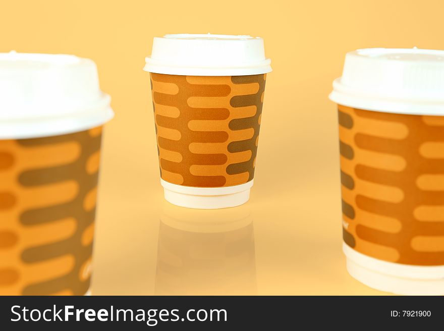 Takeaway coffee cups isolated against an orange background