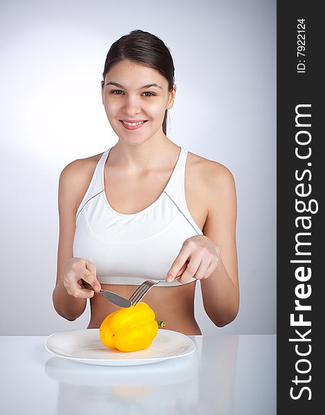 Woman cutting a yellow pepper on a plate. Woman cutting a yellow pepper on a plate