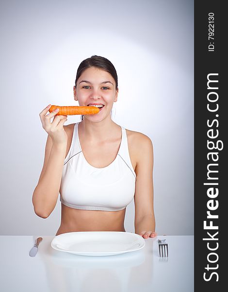 Happy woman biting a carrot. Happy woman biting a carrot