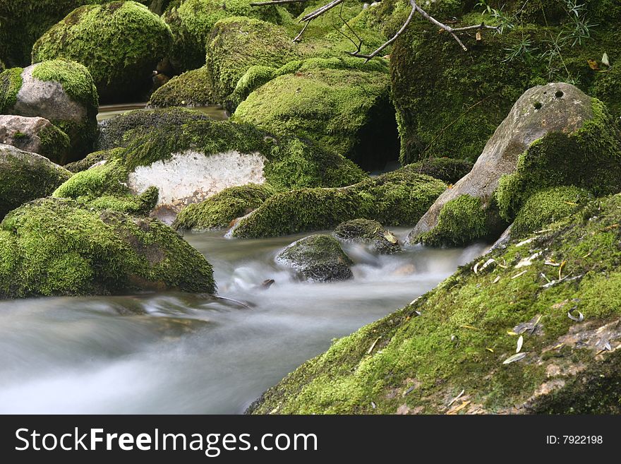 Long exposure shot of soft flowing mountain creek. Cascades of subsidiary stream of Soca river. Bovec. Slovenia. Europe. Long exposure shot of soft flowing mountain creek. Cascades of subsidiary stream of Soca river. Bovec. Slovenia. Europe