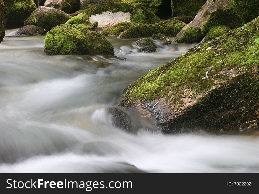 Long exposure shot of soft flowing mountain creek. Cascades of subsidiary stream of Soca river. Bovec. Slovenia. Europe. Long exposure shot of soft flowing mountain creek. Cascades of subsidiary stream of Soca river. Bovec. Slovenia. Europe