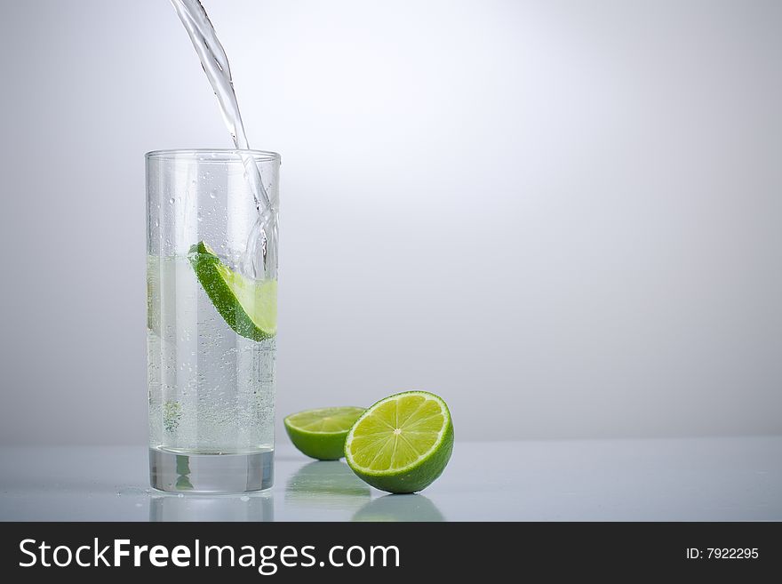 Filling a glass of water with limes