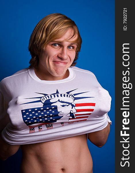 Funny smiling blond man in white T-shirt with symbol of America. Funny smiling blond man in white T-shirt with symbol of America