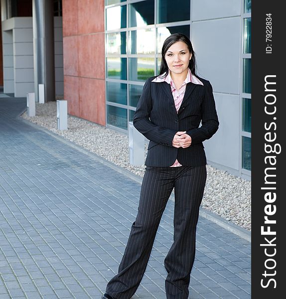 Attractive brunette businesswoman in front of office. Attractive brunette businesswoman in front of office