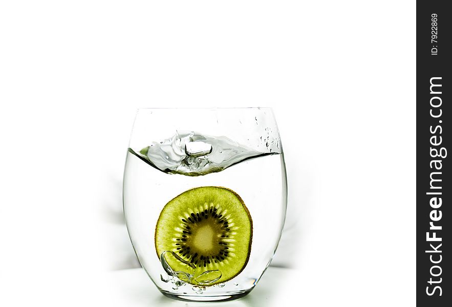 Kiwi fruit splashed into glass of water