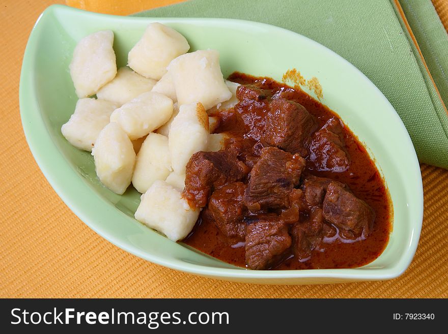 Beef goulash with gnocchi on plate