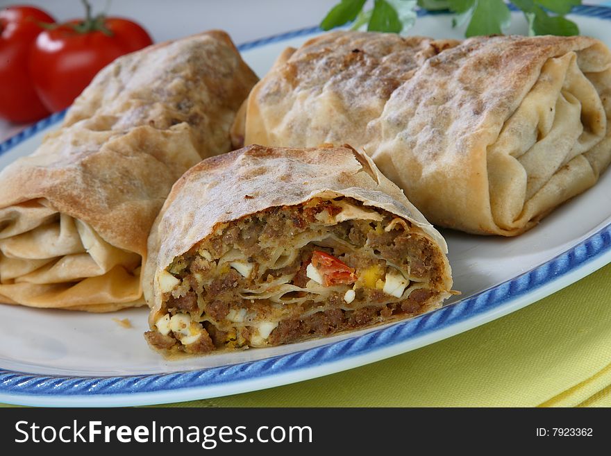 Rolled pastry with meat on plate