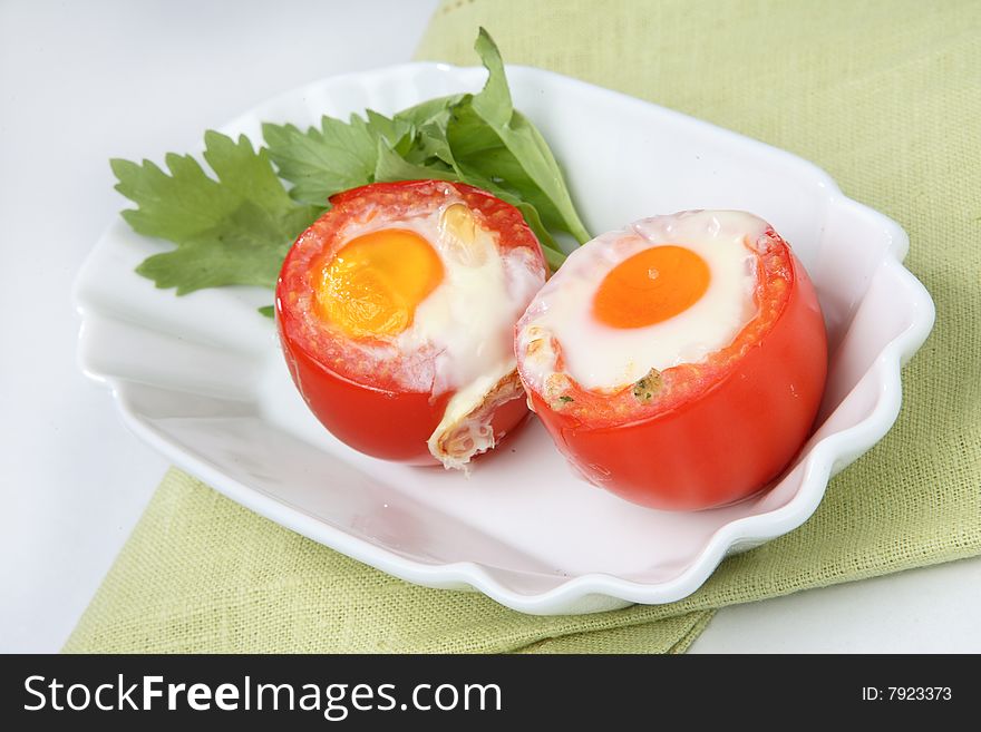 Two fried eggs on fresh tomato on plate