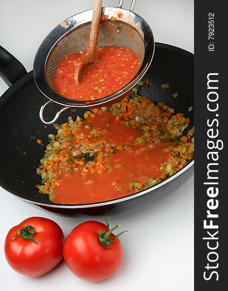 Pressing cooked tomatoes in sauce