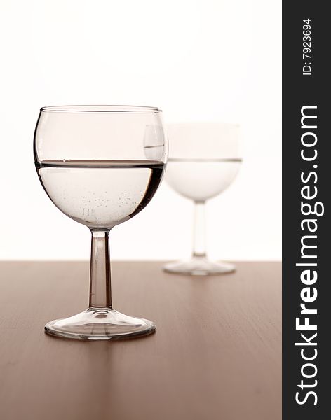 Two wine glasses in backlight on white contrast background