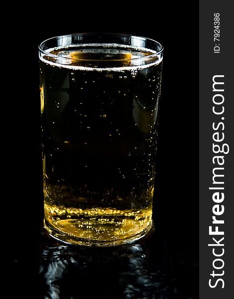 A glass of cold beeron a black backgraund