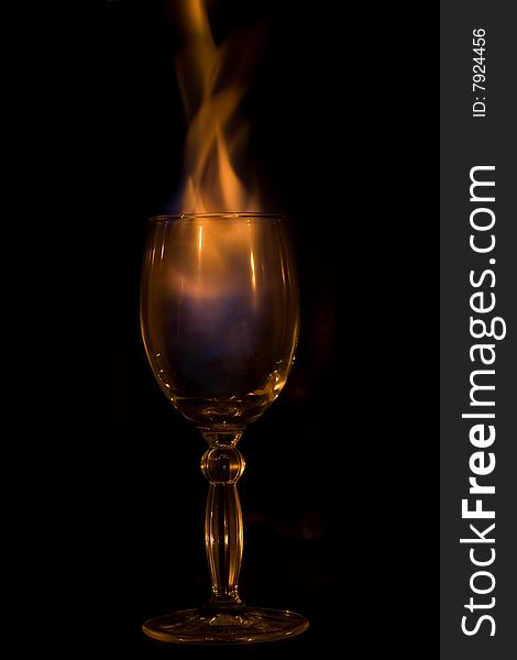 Glass, cocktail, fire. Isolated on a black background