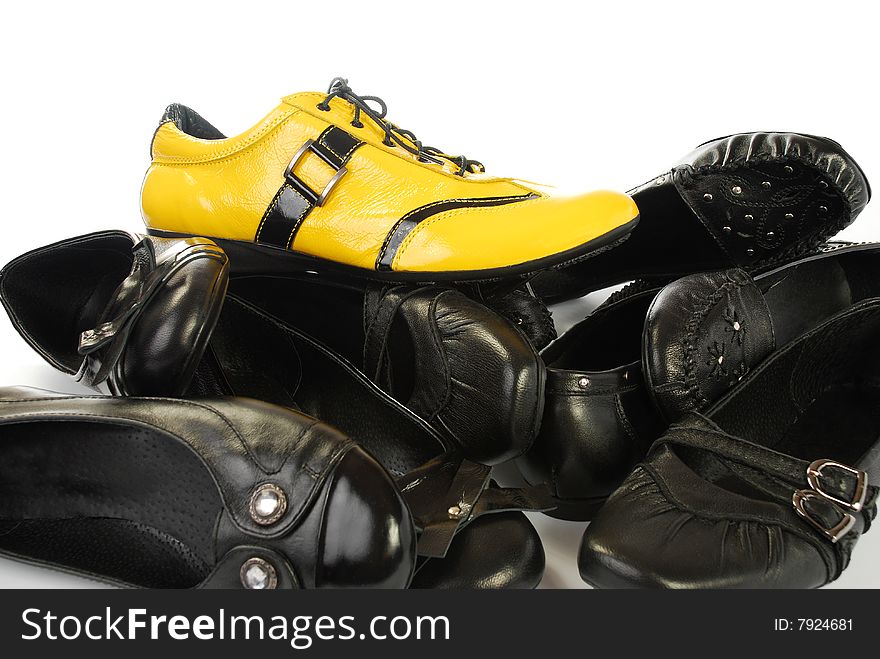Many black shoes and from above one yellow
