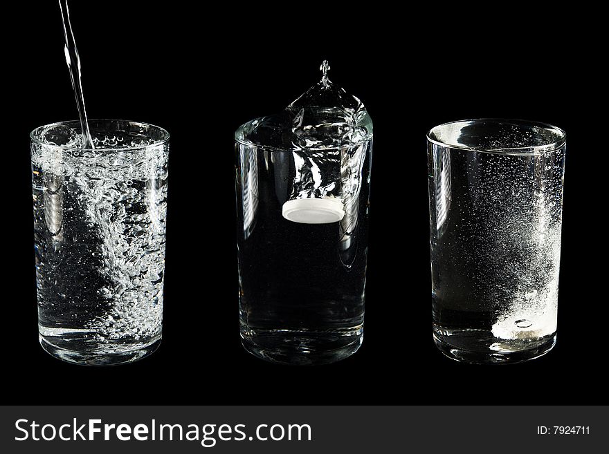 Glasses with water and a tablet. Isolated on a black background
