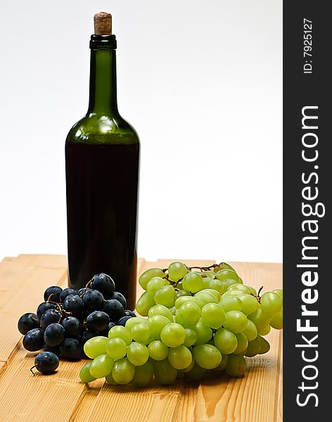 Grape and bottle on wooden table