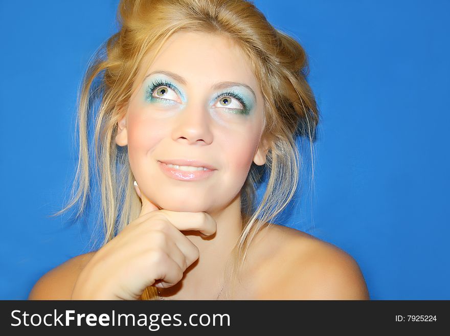 The young beautiful girl on a dark blue background. The young beautiful girl on a dark blue background